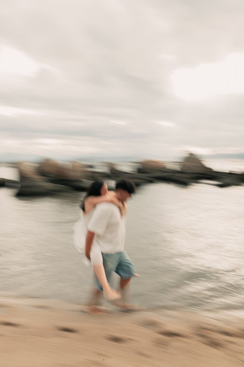 A couple sharing a piggyback ride beside the sea