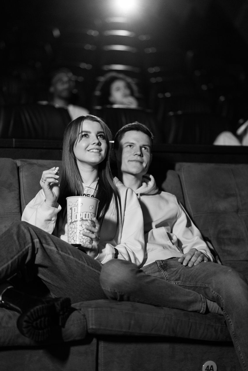 A couple sharing a moment at the cinema, in black and white